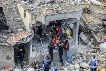 TERUS PERANGI HAMAS: Penduduk membantu menyelamatkan mangsa yang cedera dan terbunuh dalam serangan Israel ke atas kem pelarian di al-Maghazi, di tengah Gaza, pada 25 Disember, sedang Perdana Menteri Israel, Encik Benjamin Netanyahu, berikrar akan memerangi Hamas. 