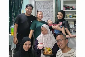 Cik Normah A Rahman (memegang kek) bergambar bersama (belakang, dari kiri) menantunya, Encik Arriyan Sabri; anaknya, Cik Siti Norhasikhin Hassan; menantunya, Cik Rosiyana Selamat; (depan, dari kiri); anaknya, Siti Nurulshafiqah Hassan; dan menantunya yang hanya dikenali sebagai Encik Firwan, sebelum kebakaran pertama berlaku di flatnya di Blok 223A Sumang Lane, Punggol, pada 1 Mei.