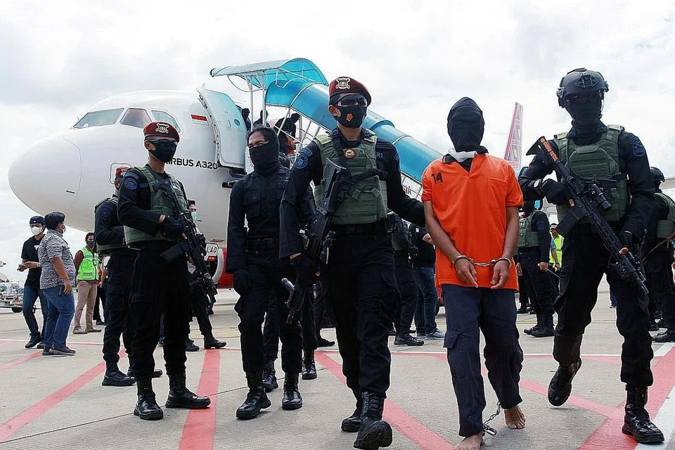 PENANGKAPAN SUSPEK PENGGANASAN: Anggota pasukan anti-pengganasan elit Indonesia Densus 88 mengawal suspek pengganas Taufik Bulaga, yang dikenali sebagai Upik Lawanga, yang tiba di Lapangan Terbang Soekarno Hatta di Tangerang, dekat Jakarta pada 16 Disember 2020. - Foto ANTARA 