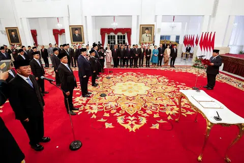 Presiden Indonesia, Encik Prabowo Subianto (kanan) mengangkat sumpah dan membaca ikrar, diikuti oleh para menteri semasa pelantikan Kabinet di Istana Presiden, Jakarta, pada 21 Oktober. ‘Kabinet Merah Putih’ Encik Prabowo merangkumi 48 kementerian dengan lebih 100 menteri dan timbalan.