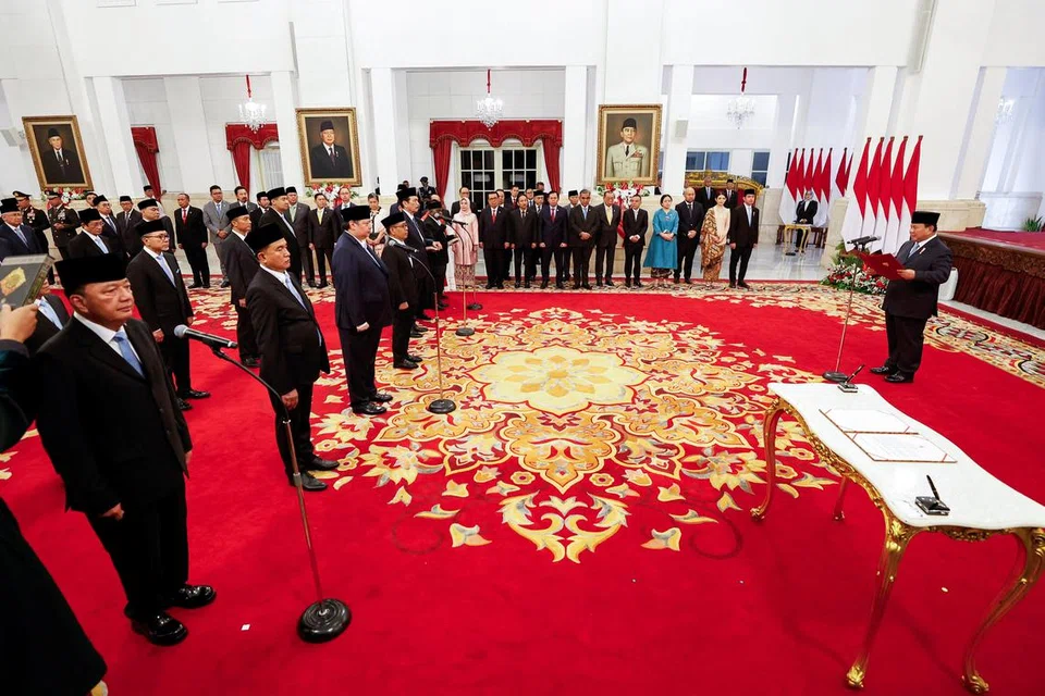 Presiden Indonesia, Encik Prabowo Subianto (kanan) mengangkat sumpah dan membaca ikrar, diikuti oleh para menteri semasa pelantikan Kabinet di Istana Presiden, Jakarta, pada 21 Oktober. ‘Kabinet Merah Putih’ Encik Prabowo merangkumi 48 kementerian dengan lebih 100 menteri dan timbalan.