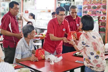 MERIAHKAN SAMBUTAN: Dr Faishal (tiga dari kanan) bersama sukarelawan Mesra mengagihkan beg yang mengandungi buah limau kepada masyarakat Cina di kawasan Chinatown semalam. - Foto CMG