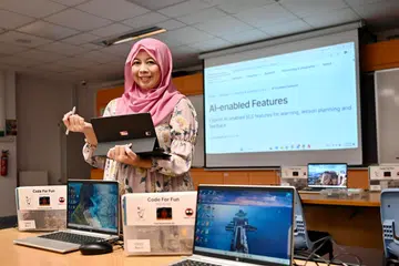 Di Sekolah Menengah Bukit Panjang Government High (BPGHS), pelajar digalakkan menggunakan pelbagai perisian kecerdasan buatan (AI) sambil menilai kesahihan kandungan yang dihasilkan. Digambarkan ialah Ketua Jabatan (Sains), Cik Alina Ahmad Sany, bersama pelbagai perisian AI yang disediakan untuk kegunaan pelajar.
