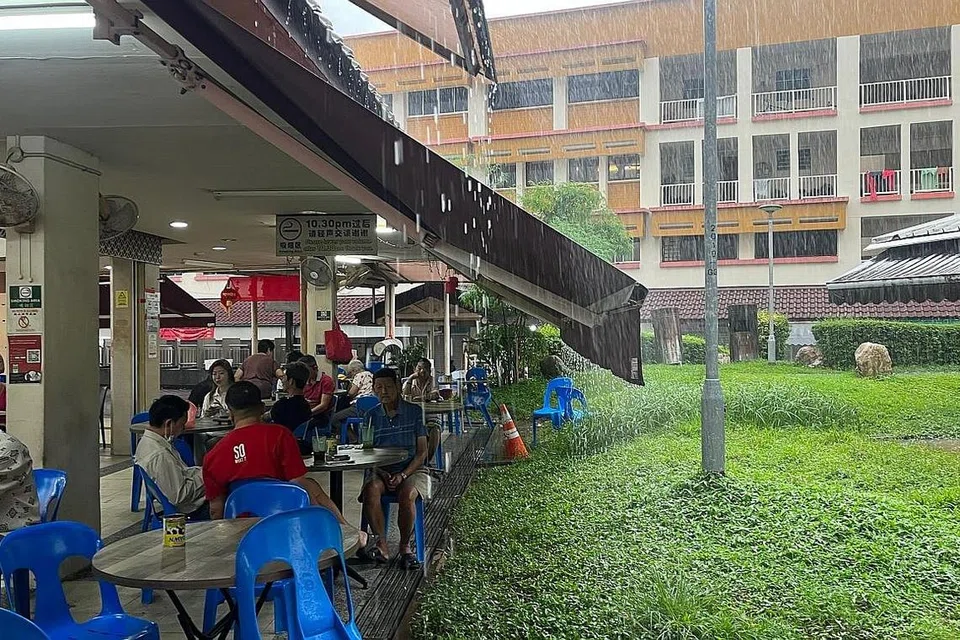 HUJAN LEBAT: Sebuah kedai kopi di Tampines semasa hujan lebat pagi semalam. - Foto BH oleh BENJAMIN SEETOR