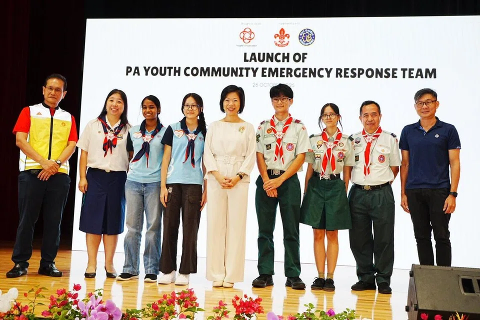 SERTAI PASUKAN KECEMASAN: Menteri Negara Kanan (Ehwal Luar merangkap Ehwal Dalam Negeri), Cik Sim Ann (tengah) bersama Pengerusi Majlis Eksekutif Jawatankuasa Kecemasan dan Penglibatan Masyarakat (C2E), Encik Mohd Yusoff Yacob (kiri); Ketua Pesuruhjaya Pandu Puteri Singapura, Cik Koh-Teh Yi Wen (dua dari kiri); Timbalan Ketua Pesuruhjaya Persatuan Pengakap Singapura, Encik Andrew Ang (dua dari kanan); Ketua Pengarah Eksekutif Persatuan Rakyat (PA), Encik Jimmy Toh (kanan); bersama beberapa pandu puteri dan pengakap termasuk Alia Rifqi (tiga dari kanan); semasa pelancaran Pasukan Respons Kecemasan Masyarakat (Cert) Belia PA di Kelab Masyarakat Ulu Pandan pada 26 Oktober.