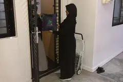 Cik Norsiha Aboo Bakar (kanan), menyerahkan daging korban, yang penyembelihannya dilakukan di Australia, ke rumah penerima bantuan zakat di Yishun. 