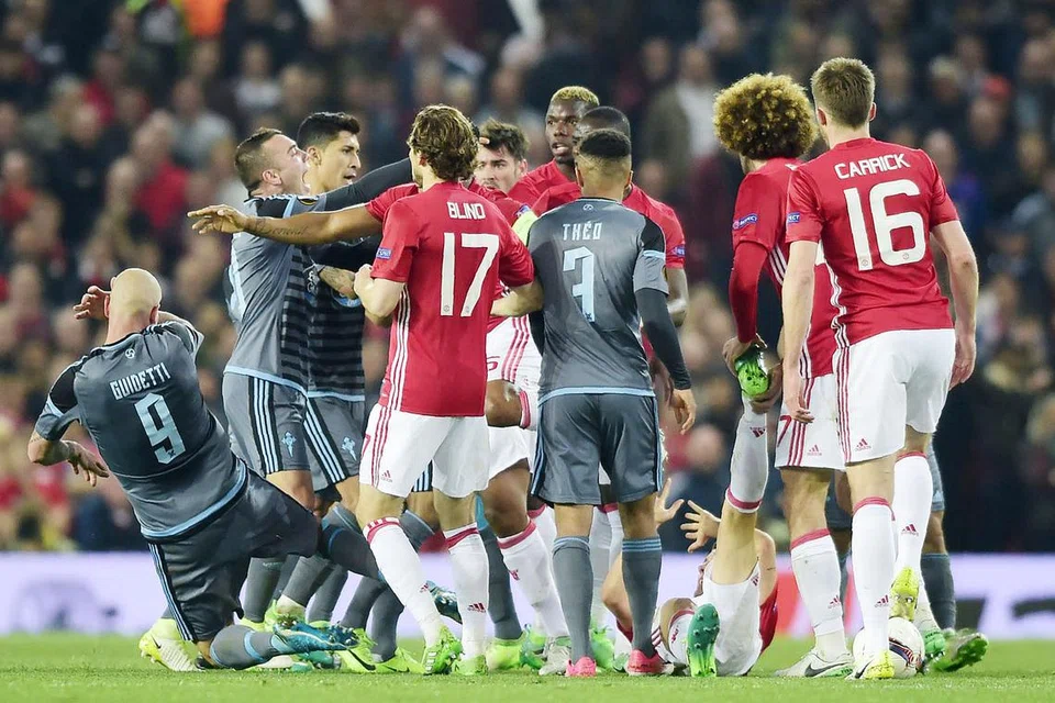 DICEMARI INSIDEN GADUH: Pemain Celta, John Guidetti (kiri), terjatuh ke padang selepas terlibat dalam pergaduhan dengan pemain pertahanan United, Eric Bailly (terlindung), dalam pertemuan separuh akhir kedua Liga Europa dinihari semalam. - Foto-foto AFP