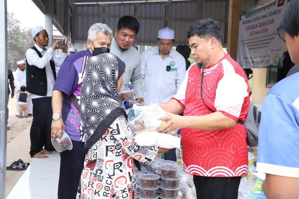 Peserta Ziarah Amal Kemboja 2024 mengedarkan sumbangan makanan, termasuk pemberian kurma untuk dinikmati semasa Ramadan, kepada para penduduk.