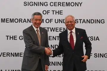 JALINAN DUA NEGARA SEMAKIN ERAT: Perdana Menteri Lee Hsien Loong berjabat tangan dengan Perdana Menteri Malaysia, Datuk Seri Najib Tun Razak, semasa satu sidang media bersama menyusuli majlis menandatangani memorandum persefahaman (MOU) bagi Projek Kereta Api Laju (HSR) Kuala Lumpur-Singapura di Putrajaya semalam. - Foto AFP
