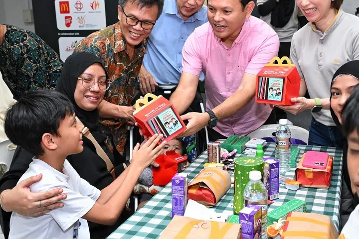 Menteri Negara Kanan (Pertahanan merangkap Kemampanan dan Sekitaran) Encik Zaqy Mohamad, menyampaikan pek makanan McDonald’s untuk acara berbuka puasa pada 7 Mac kepada para tetamu. Beliau ditemani (tiga dari kiri), Pengerusi Rangkaian Penduduk Marsiling Greenview Zon 9 Encik Mun Yow Cheong; Ketua Pegawai Eksekutif Sheng Siong, Encik Lim Hock Chee; dan Pengarah Urusan McDonald’s Singapura, Cik May Yin.