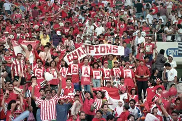 Penyokong setempat bersorakan dan mengangkat kain rentang untuk memberi sokongan kepada pasukan bola sepak kesayangan di Stadium Negara lama di Kallang pada 1994.