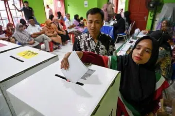 Seorang wanita membuang undi dalam pilihan raya umum 2024 pada 14 Februari di sebuah pusat mengundi di Banda Aceh, Aceh.