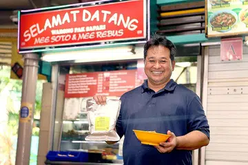 KEMBANGKAN NIAGA: Encik Sumadi telah mengeluarkan pes kuah soto yang dijual di gerainya di Warong Pak Sapari di Pusat Penjaja Adam Road. - Foto BH oleh ZHANG XUAN