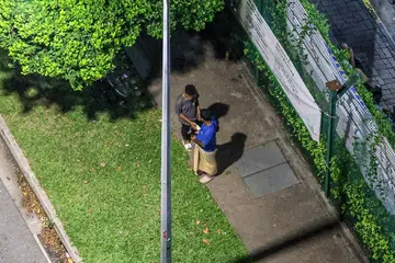 BELI ROKOK HARAM: Individu yang disyaki terlibat dalam transaksi pembelian dan penjualan Rokok Tidak Dibayar Duti (DUC) di luar dormitori di Mandai Estate.