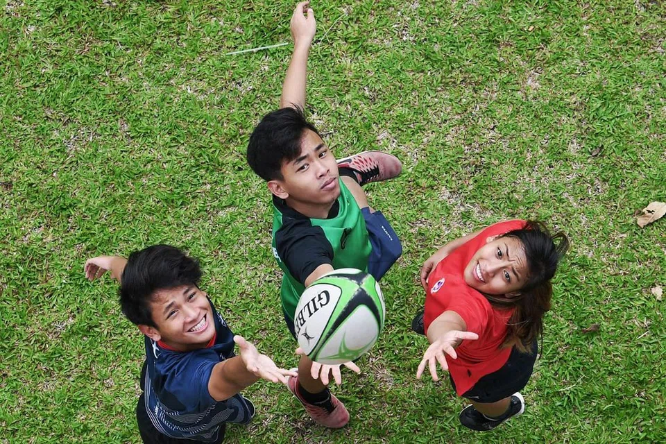 SAMA MINAT: Siti Rasyidah Mohd Shariff, 25 tahun, Ahmad Rasyid Mohd Shariff, 22 tahun, dan Ahmad Rasyidee Mohd Shariff, 18 tahun, adalah adik-beradik yang berminat jadi pemain ragbi. - Foto KHALID BABA