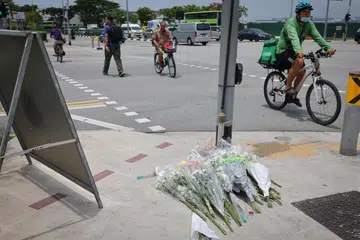 Orang awam meletakkan bunga di persimpangan Tampines sebagai penghormatan dan salam takziah kepada dua orang yang terbunuh dalam kemalangan jalan raya baru-baru yang berlaku pada 22 April. 