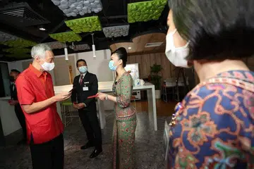 Encik Lee memberi hong bao kepada kru kabin dan juruterbang SIA serta kakitangan sokongan yang bertugas di Pusat Kawalan Kru Kabin SIA pada hari pertama Tahun Baru Cina.