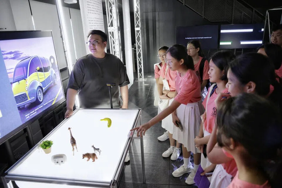 CUBA GUNA AI: Pelajar sekolah menengah cuba memasukkan input yang  berbeza supaya AI dapat menghasilkan reka bentuk produk yang berlainan semasa lawatan Eksperimen Digital Interaktif baru dengan AI Studio (Ideas) di Sekolah Reka Bentuk Politeknik Temasek (TP).