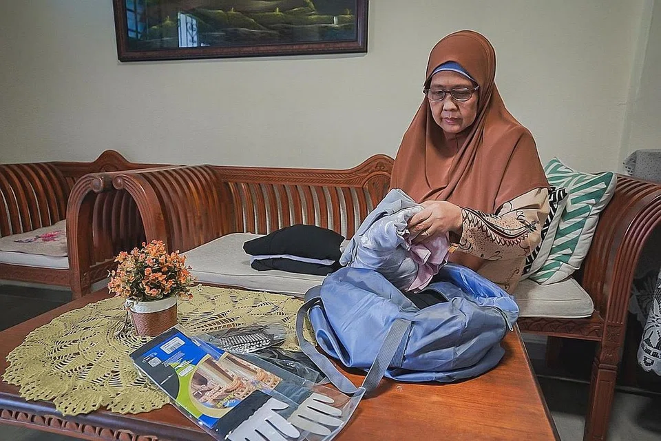 HAMPA TAPI REDA: Cik Sukarti sedang membelek barangan keperluan haji yang dibelinya dan anggota keluarga sebelum tiba gilirannya ke haji pada 2020. Namun disebabkan pandemik yang belum berakhir, nampaknya Cik Sukarti perlu terus bersabar menanti gilirannya. - Foto BH oleh NUR DIYANA TAHA