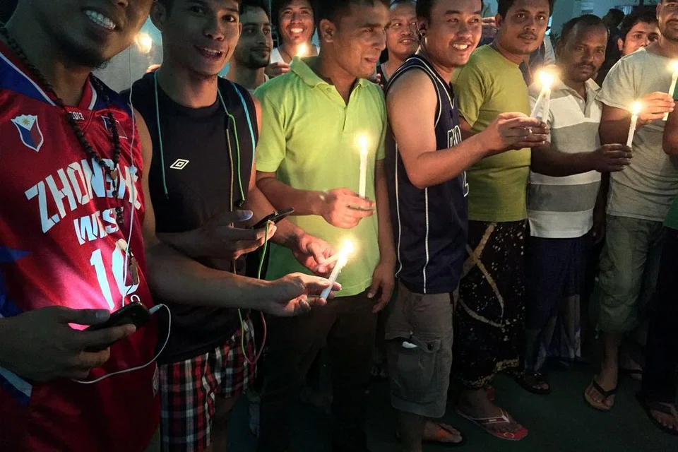 PADAMKAN LAMPU DEMI BUMI: Pekerja asing di dormitori The Leo mematikan lampu dan menyalakan lilin sempena Earth Hour Sabtu lalu. - Foto ihsan YUSOF LATEEF