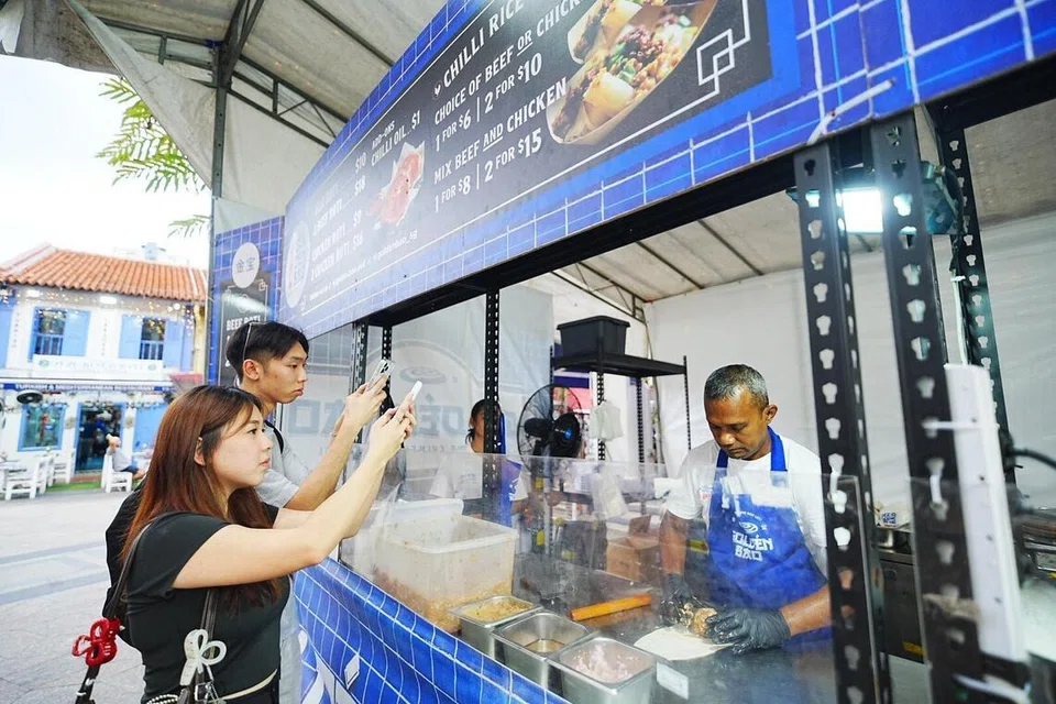 Pelanggan menyaksikan proses memasak roti Golden Bao di Kampong Gelam. 
