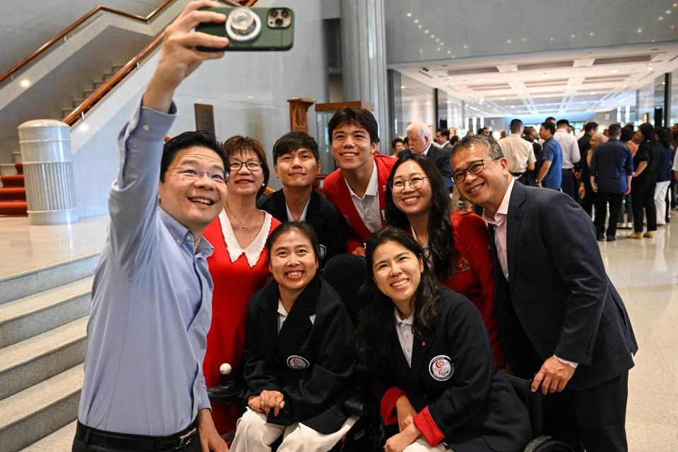 Perdana Menteri, Encik Lawrence Wong (paling kiri), berswafoto dengan atlet yang mewakili Singapura di Sukan Paralimpik dan Olimpik Paris di Parlimen pada 16 Oktober. Bersama mereka adalah Menteri Kebudayaan, Masyarakat dan Belia, Encik Edwin Tong (paling kanan).