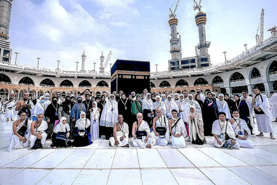 KENANGAN DI DEPAN KAABAH: Para jemaah yang mengikuti rombongan dari TravelConnect.sg bergambar di depan Kaabah. Ramai masyarakat Islam Singapura memilih untuk ke Tanah Suci pada musim percutian ini. - Foto TRAVELCONNECT.SG