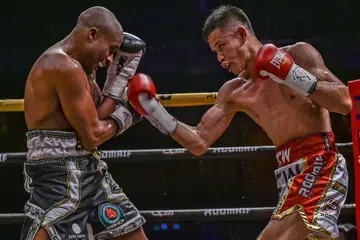 SAING HEBAT: Jaguh Singapura, Mohamad Ridhwan Ahmad (kanan), melepaskan tumbukan ke arah Paulus Ambunda, dalam pertarungan merebut kejuaraan dunia kelas 'super bantam' IBO pada 29 September lalu. Ambunda menang melalui keputusan 'split'. - Foto DAVID ASH / RINGSTAR