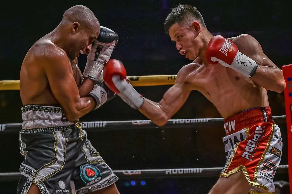 SAING HEBAT: Jaguh Singapura, Mohamad Ridhwan Ahmad (kanan), melepaskan tumbukan ke arah Paulus Ambunda, dalam pertarungan merebut kejuaraan dunia kelas 'super bantam' IBO pada 29 September lalu. Ambunda menang melalui keputusan 'split'. - Foto DAVID ASH / RINGSTAR