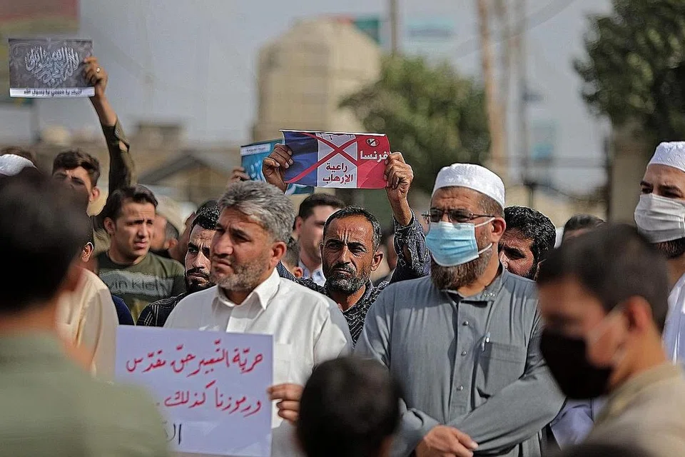 ANCAMAN PENGGANASAN TERUS WUJUD: Menyusuli serangan di Perancis berikutan pemenggalan kepala seorang guru, Samuel Paty, Presiden Perancis Macron telah mengeluarkan kenyataan yang memberi penghormatan kepada Paty dan mempertahankan hak di Perancis. Ini mencetuskan tunjuk perasaan di beberapa negara termasuk di Syria yang mengibarkan bendera Perancis dengan kekata 'Perancis, penaja pengganasan'. Insiden ini turut disentuh Encik Shanmugam dalam ucapannya sempena Seminar RRG semalam. - Foto AFP