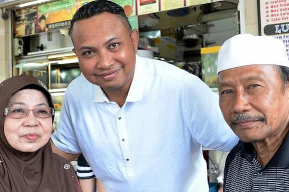 BOON LAY NASI LEMAK POWER: Encik Badrol Hisam (tengah) bersama ibu bapanya, Cik Nyonya Mohd Shah dan Haji Borhan Jais, memanggang bahan kacang dalam nasi lemak gerainya yang lebih sihat berbanding menggoreng.