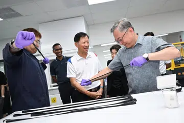 Timbalan Perdana Menteri dan Menteri Perdagangan dan Perusahaan, Encik Gan Kim Yong (kanan), melawat Samwoh Corporation untuk meninjau projek inovasi mereka. Bersama beliau ialah Jurutera Eksekutif Samwoh, Encik Chow Wee Kang (kiri), dan Ketua Pegawai Operasi Samwoh, Dr Ho Nyok Yong (tengah). 