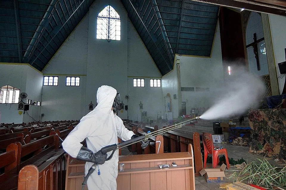 BASMI KUMAN: Seorang pekerja kesihatan melakukan pembasmian kuman di Gereja Santa Maria di Palu, Jawa Tengah, semalam, sedang masyarakat Kristian meraikan perayaan Hari Natal esok. - Foto AFP