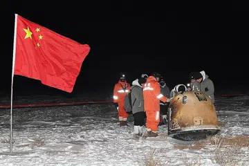 SELAMAT MENDARAT: Penyelidik mengkaji di sekitar kapsul Chang'e-5 yang membawa sampel dari Bulan selepas ia mendarat. - Foto REUTERS
