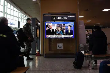 DUNIA GEMBIRA: Warga Seoul di Korea Selatan dirakam menonton laporan televisyen mengenai upacara angkat sumpah Encik Joe Biden di sebuah stesen kereta api semalam. - Foto EPA-EFE