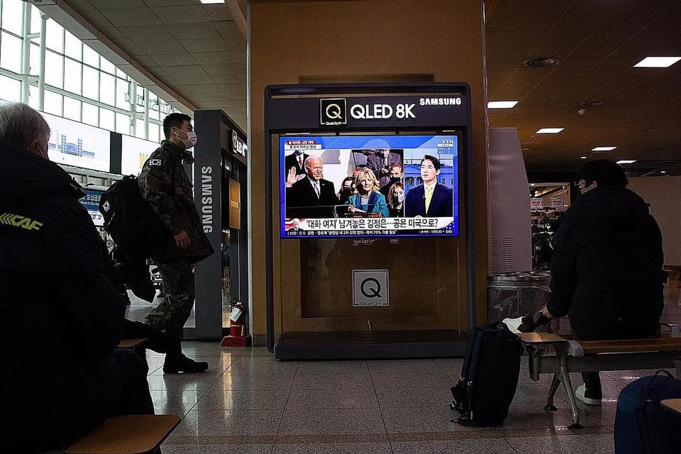 DUNIA GEMBIRA: Warga Seoul di Korea Selatan dirakam menonton laporan televisyen mengenai upacara angkat sumpah Encik Joe Biden di sebuah stesen kereta api semalam. - Foto EPA-EFE