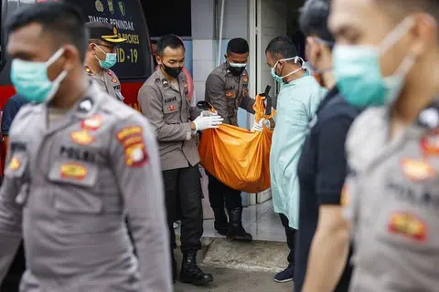 Pegawai polis mengangkat beg mayat selepas satu kebakaran di penjara, di sebuah hospital di Tangerang, Banten, Indonesia pada Rabu (8 Sept).