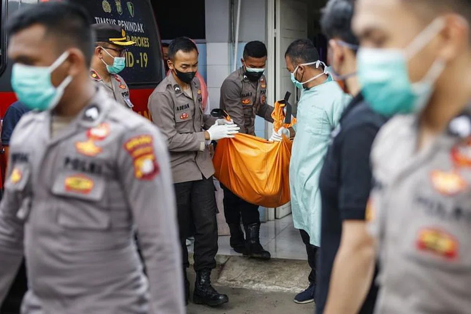 Pegawai polis mengangkat beg mayat selepas satu kebakaran di penjara, di sebuah hospital di Tangerang, Banten, Indonesia pada Rabu (8 Sept).