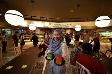 LUAS NIAGA: Cik Mastura Didih Ibrahim bergambar di gerai makan Hajah Maimunah Mini, yang menawarkan beberapa sajian popular restoran utamanya, seperti ikan bakar dan asam pedas ikan pari. - Foto BH oleh LIM YAOHUI