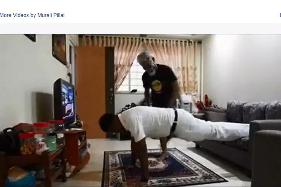 HUBUNGAN MESRA DENGAN PENDUDUK: Encik Murali melakukan 'push up' semasa menemui penduduk berusia 66 tahun, Encik Razali, di rumahnya. - Foto FACEBOOK K. MURALIDHARAN PILLAI