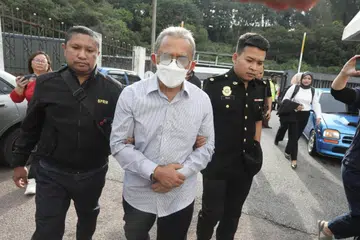 Bekas Datuk Bandar Johor Bahru, Datuk Adib Azhari Daud, 64 tahun (tengah), didakwa di Mahkamah Sesyen Johor Bahru atas 12 tuduhan menerima rasuah dengan nilai keseluruhan RM1.55 juta ($440,000) antara tahun 2020 hingga 2021.
