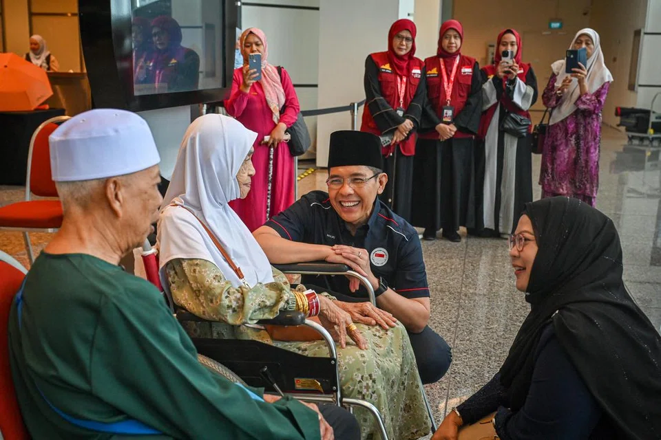 Menteri di Pejabat Perdana Menteri, Dr Mohamad Maliki Osman (dua dari kanan), berbual dengan Cik Sapiah Mamat (dua dari kiri), 88 tahun, jemaah haji paling tua dalam rombongan pada 2024. Cik Sapiah, yang bersemangat walaupun menghadapi masalah mobiliti, penyakit darah tinggi dan jantung, ghairah untuk menunaikan ibadah haji.