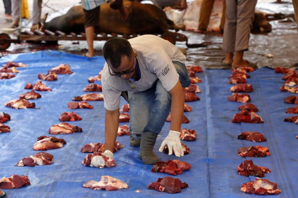 Relawan di Aceh, Indonesia, menyiapkan daging korban untuk diagihkan kepada orang ramai pada 6 Jun.