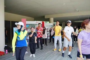Cik Mariam (dua dari kiri) sertai penduduk termasuk Cik Idayu Remie (paling kiri) dalam sesi zumba di Bukit Canberra sempena Fiesta Kesihatan GRC Sembawang 2024 pada 13 Oktober 2024. Turut bersama mereka ialah bekas pemain bola sepak negara Shaiful Esah, Hassan Sunny dan Nazri Nasir.
