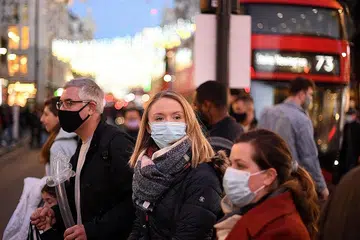 JAGA KESIHATAN: Sesetengah orang dilihat memakai pelitup semasa melintasi Oxford Street di tengah London pada 4 Disember lalu sedang perintah penggunaan pelitup diwajibkan semula di England disebabkan kebimbangan meningkatnya penularan varian Omicron di Eropah. - Foto AFP