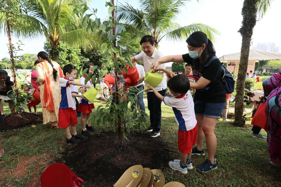 Perdana Menteri, Encik Lawrence Wong, bersama kanak-kanak daripada Sparkletots Yayasan Masyarakat PAP (PCF) serta para penduduk, dan pemimpin akar umbi yang turut terlibat dalam acara menanam pokok pada Mei 2023. 