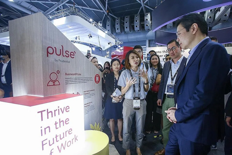 KIAN CANGGIH: Encik Wong (kanan) semasa mengunjungi beberapa reruai di Festival Fintech Singapura 2022 di Singapore Expo. - Foto ZAOBAO