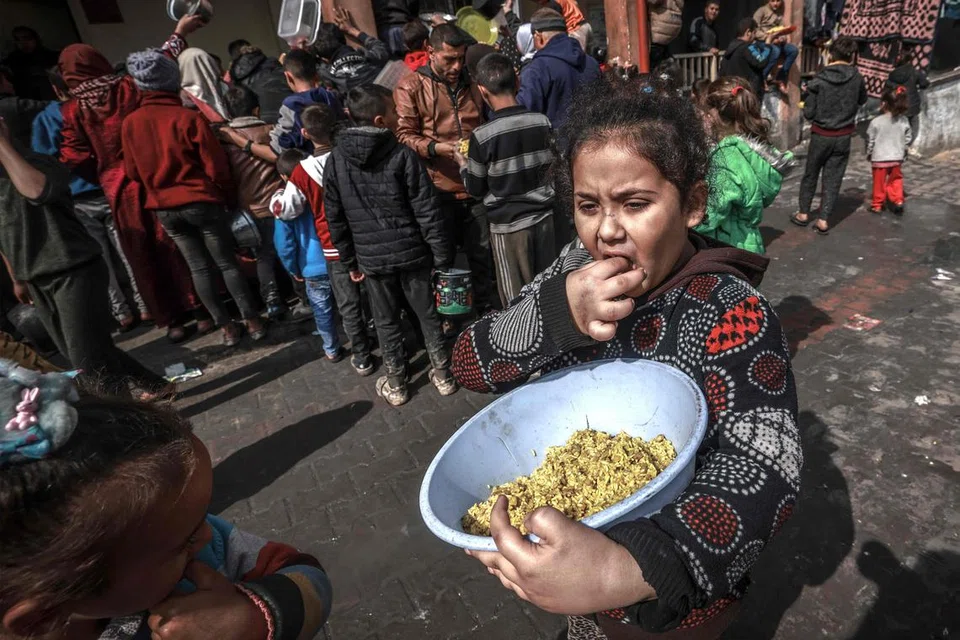 Seorang kanak-kanak Palestin sedang makan yang disediakan di sebuah kem di Rafah sedang berlakunya pertempuran antara Israel dengan Hamas di kawasan selatan Gaza itu.