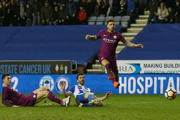 JARING GOL KEMENANGAN: Grigg (tengah) jaring gol tunggal perlawanan sedang pemain Manchester City, Kyle Walker (kanan) dan Aymeric Laporte hanya dapat memerhatikan. - Foto REUTERS