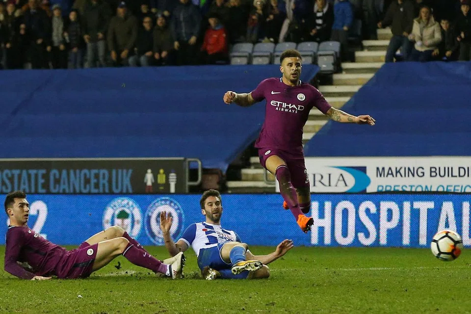 JARING GOL KEMENANGAN: Grigg (tengah) jaring gol tunggal perlawanan sedang pemain Manchester City, Kyle Walker (kanan) dan Aymeric Laporte hanya dapat memerhatikan. - Foto REUTERS